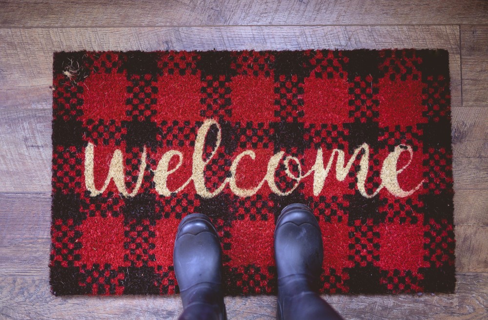 overhead shot person standing welcome mat