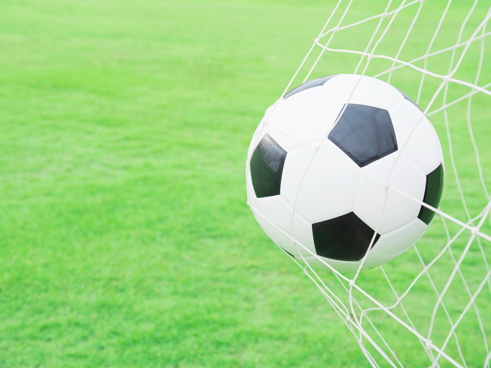 shooting shot football goal net with green grass field background